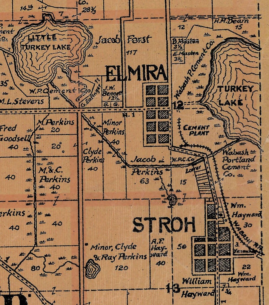 A detail of a printed county map on tan paper. At the upper left a lake is lettered LITTLE TURKEY LAKE and at the right a larger one is lettered TURKEY LAKE. Between them a small grid of blocks is lettered ELMIRA, and beside the larger lake the words CEMENT PLANT sit among curving lines of track. Several parcels carry the name Wabash Portland Cement Co. At the lower right a second grid of blocks is lettered STROH.