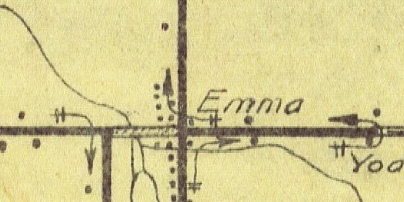 A small area of the map. The word Emma in small italic letters beside a road crossing, with a few house dots, and no circle or ring of any kind beside it.